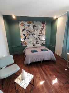 IngouvilleManoir des Carreaux Chambres d'hôtes的卧室配有一张床,墙上挂有绘画作品