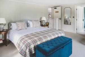 勒德洛The Clive Arms的一间卧室配有一张大床和蓝色的搁脚凳