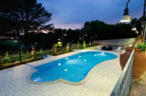 普雷西切ViverE' Resort的夜间后院的小型游泳池
