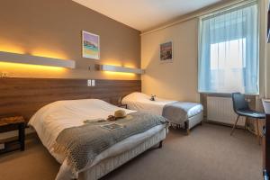 瓦讷安妮布列塔尼酒店的酒店客房设有两张床和窗户。