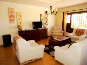 阿索马达Casita Joli的客厅配有两把白色椅子和电视