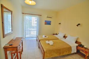 干尼亚法拉斯阿姆酒店 的酒店客房设有两张床、一张书桌和窗户。