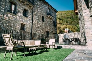 萨尔维塞Casa Rural Monte Perdido的大楼前设有带椅子和沙发的庭院