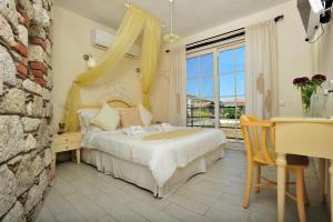 阿拉恰特Alaçatı Sultan Konak Butik Otel ℳℛ Luxury Concept的一间卧室配有一张床、一张书桌和一个窗户。