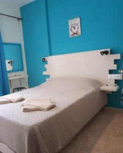 斯基亚索斯镇Sokaki rooms的卧室配有白色床和蓝色墙壁