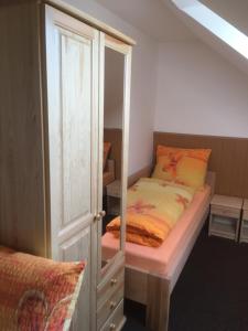 RybništěPenzion Relax的一间带一张床和一个衣柜的小卧室