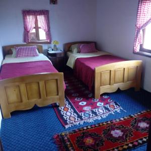 耶蒂斯特Etno guest house Lalovic的一间带两张床的卧室和地毯