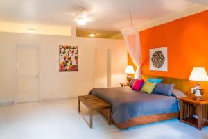 PétionvilleHotel Montana的一间卧室配有一张橙色墙壁的床