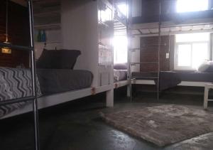 玛琅Shelter Hostel Malang的一间设有两张双层床和地毯的房间