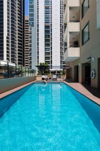 布里斯班布里斯班诗铂高级服务公寓的在建筑物游泳池游泳的人