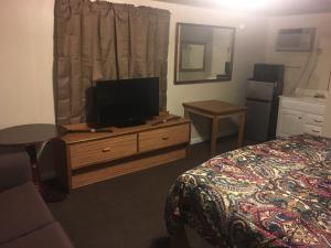 默特尔比奇Riviera Motor Lodge的一间卧室配有一张床,梳妆台上配有电视