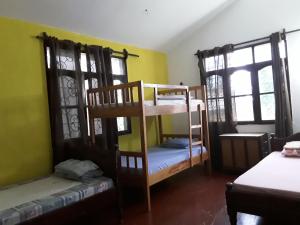 蒙巴萨Akogo House - Hostel and Backpackers的带两张双层床和两扇窗户的房间