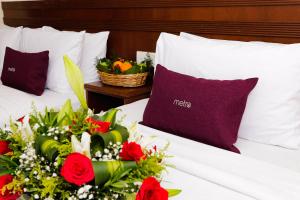 吉隆坡吉隆坡中心都会酒店的一张带红玫瑰和一篮鲜花的床