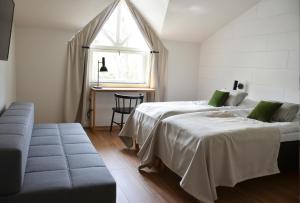 图尔库HeseHotelli Turku Kaskentie的一间卧室设有两张床、一张沙发和一个窗口