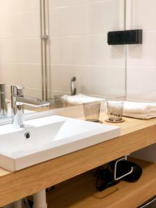 图尔库HeseHotelli Turku Kaskentie的浴室柜台配有白色水槽和镜子