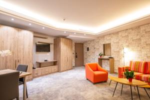 朱拜勒Maximus Hotel Byblos的客厅配有橙色沙发和桌子