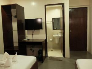 科隆Casa Coron Hotel的一间卧室,浴室内设有电视和书桌