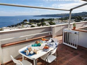 圣凯撒利亚温泉Casa con terrazza vista 180° sulla costa orientale的阳台配有餐桌,上面有食物