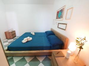 圣凯撒利亚温泉Casa con terrazza vista 180° sulla costa orientale的一间卧室配有蓝色的床和2条毛巾
