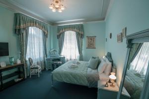 利耶帕亚Roze Villa的卧室配有一张床、一张书桌和窗户。