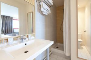 阿蒂斯蒙斯奥利高级酒店的白色的浴室设有水槽和镜子