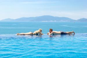 芽庄Boton Blue Hotel & Spa的两个女人躺在水里