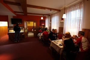 奥斯特罗德Hotel garni Harzer Hof的一群人坐在一个房间里桌子上