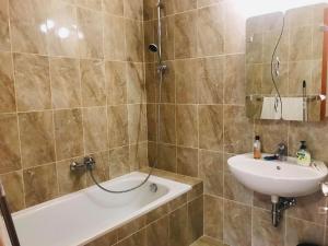 豪伊杜索博斯洛Thermal Lux apartman的带浴缸和盥洗盆的浴室
