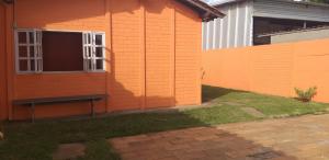 塞蒂拉瓜斯Acomodaçaoes koynonya的一座橙色房子,前面设有长凳