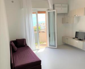 利多迪耶索罗Hotel & Residence Al Mare的客厅配有紫色沙发和窗户