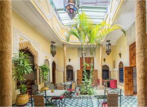 拉巴特里亚德达佐霍尔酒店的大堂设有桌椅,种植了棕榈树。