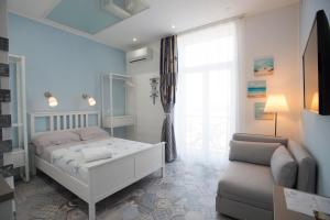 萨莱诺Nereidi Suites的卧室配有床、椅子和窗户。