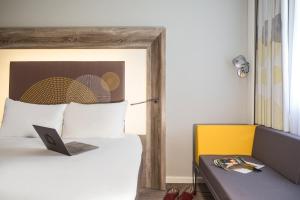 考文垂诺富特考文垂酒店的一间卧室配有一张带笔记本电脑的床