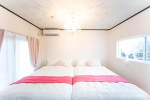 四日市9 min to Yokkaichi Tomida STN House的一间卧室配有一张带吊灯的大床
