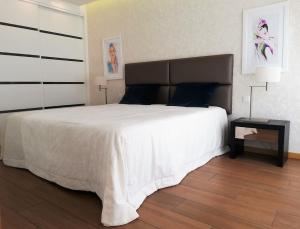 纳扎雷Apartamentos Turisticos da Nazare的卧室配有一张白色大床和一张边桌