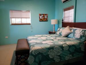 夏洛特阿马利亚Villa Indigo Sunny 1BR Apartment in Private Gated Estate的一间卧室设有一张床和蓝色的墙壁