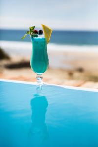 比斯卡罗斯海滩德拉普拉奇乐格兰德酒店的坐在桌子上的玻璃杯里喝的一杯绿色饮料