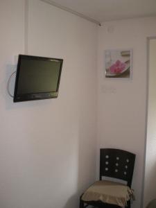 Le Nayrac劳伯格夫鲁里酒店的墙上的电视,带椅子的房间