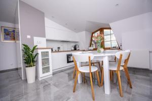 琴斯托霍瓦Apartamenty AP 17的厨房以及带白色桌椅的用餐室。