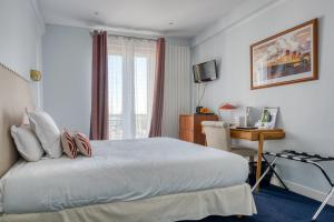 圣纳泽尔乐贝里酒店的一间卧室配有一张带书桌的床和窗户。