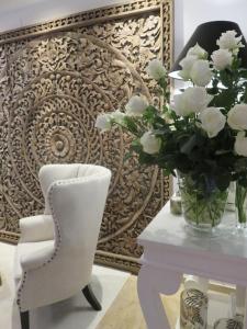 萨尔茨堡Boutiquehotel Villa Sissi的一张白色的椅子和一张桌子上的花瓶
