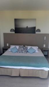 乐巴凯尔斯Hotel de la Plage - Barcares的一间卧室配有一张带蓝色枕头的大床