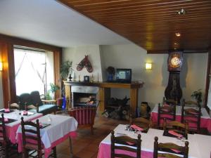 莱斯卡耐伽胡安酒店的一间带桌子、壁炉和时钟的餐厅
