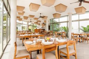 阿马蒂特兰卡维拉尔酒店的餐厅设有木桌和椅子以及大窗户。