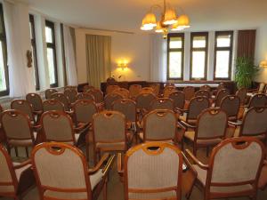 博伊龙Gäste- und Tagungshaus Maria Trost的一间设有一排椅子和吊灯的房间