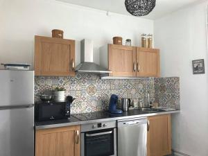 圣莱奥纳尔德诺布拉Le Compostelle Chic, Charme, Confort, Cocooning 80 m²的厨房配有冰箱和炉灶。 顶部烤箱