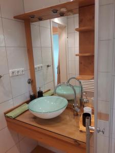 柯尼希斯湖畔舍瑙贝格雷赫公寓的一间带碗水槽和镜子的浴室