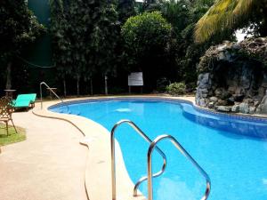 公主港快乐之源酒店的度假村内带蓝色海水和金属栏杆的游泳池
