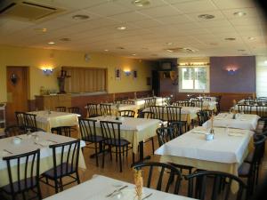 梅基嫩萨佐伊屯酒店的用餐室配有桌椅和白色的桌布