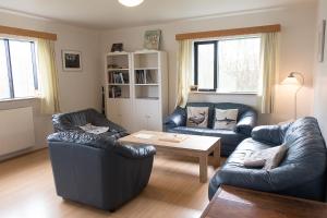 SúðavíkSudavik guesthouse的客厅配有两张真皮沙发和一张桌子